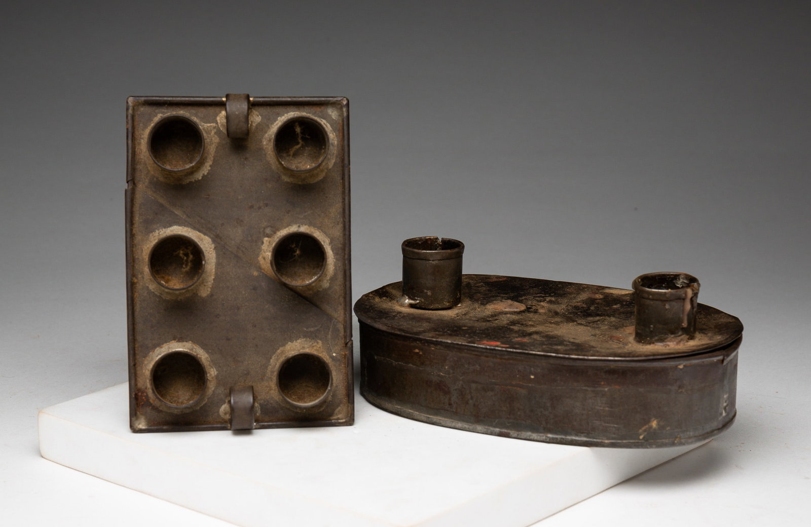TIN CANDLE HOLDER AND TINDER BOX.: American, early 19th Century. Tole tinder box two candles with six lights and six told candle plates. 5.5" x 3.5". 6.5" tin box. From the collection of the late Audrey Caspari (New Jersey).