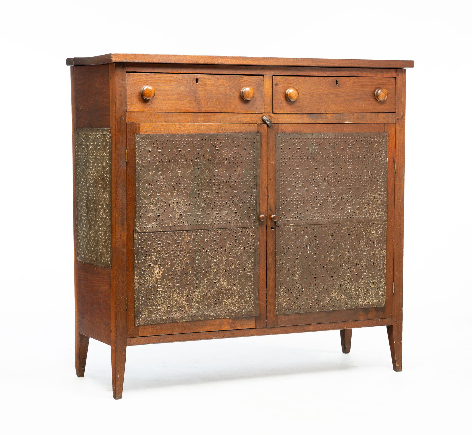 VIRGINIA PIE SAFE.: Wythe County, mid 19th Century. Walnut with poplar secondary. Two board top, two upper drawers, ends and doors with surface mounted punched tins with circular pattern and short tapered legs. Pegged an