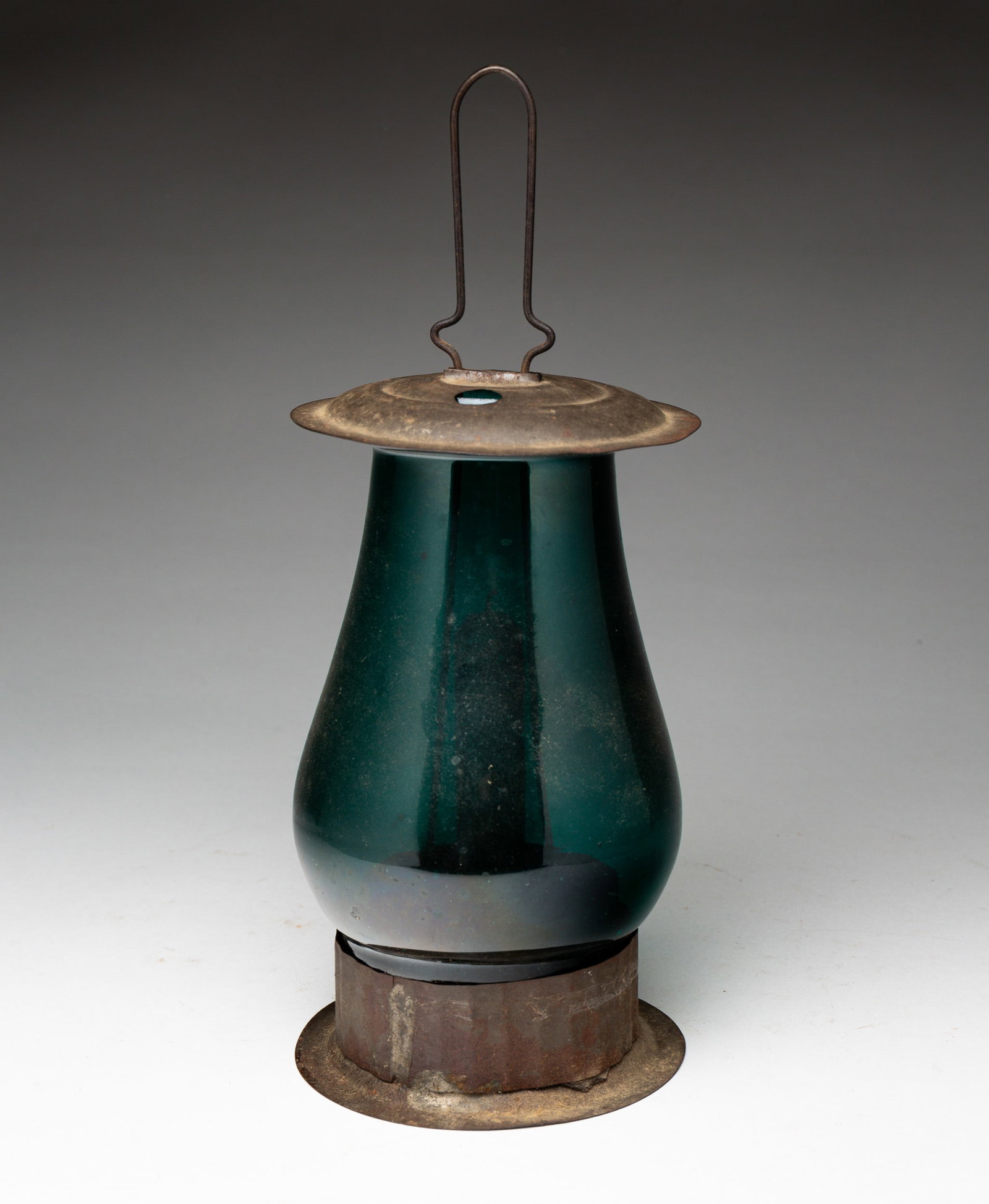 TIN CANDLE LANTERN WITH GREEN CHIMNEY.: American, 19th Century. Tin lantern with peacock green glass chimney. Base, 4.25"dia. Lantern, 11"h. From the collection of the late Audrey Caspari (New Jersey).