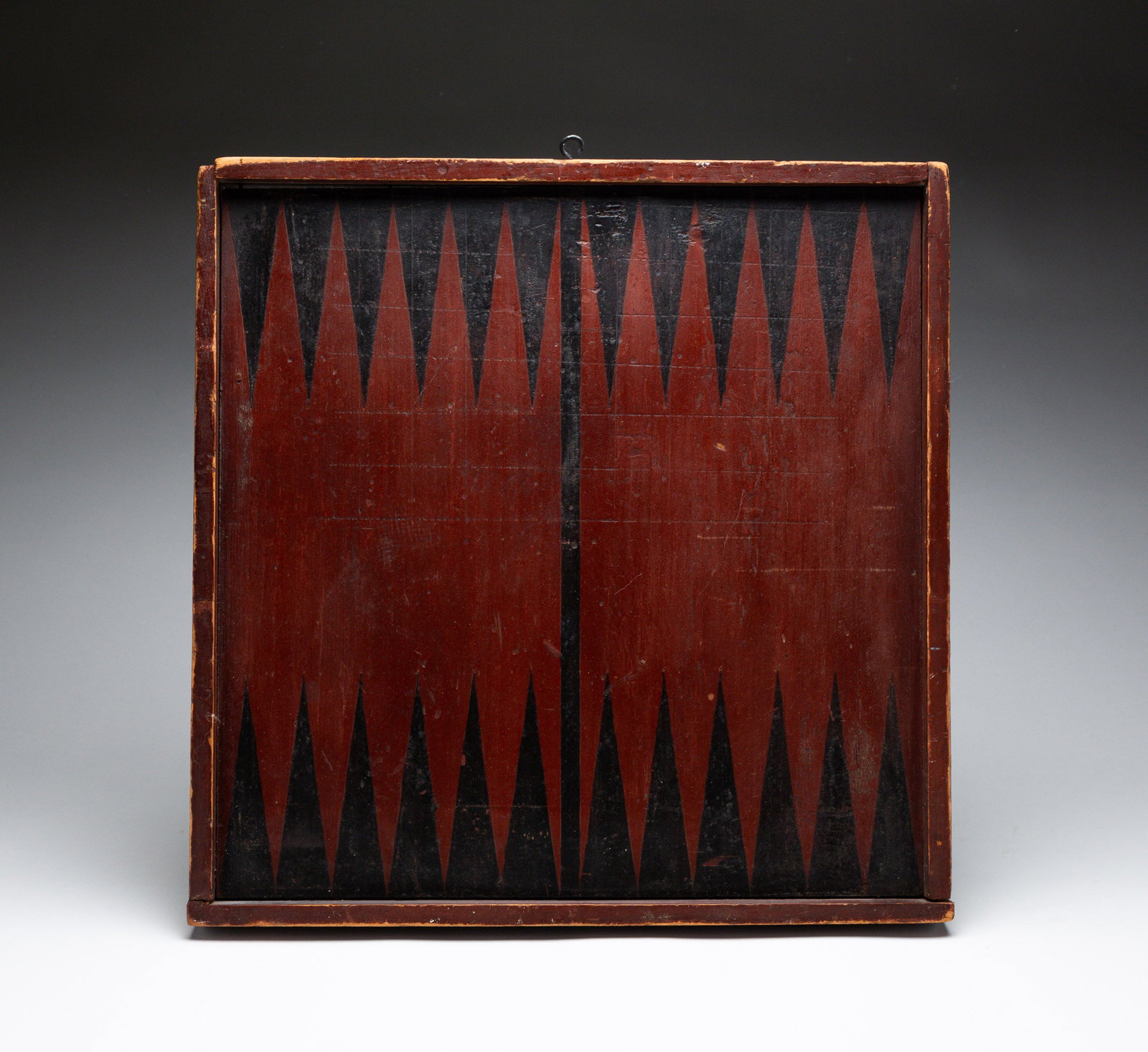 PAINTED GAME BOARD.: Nineteenth Century. Double sided red and black painted game board. Red and black checkerboard on the front and backgammon board on reverse. Approx. 16" square.