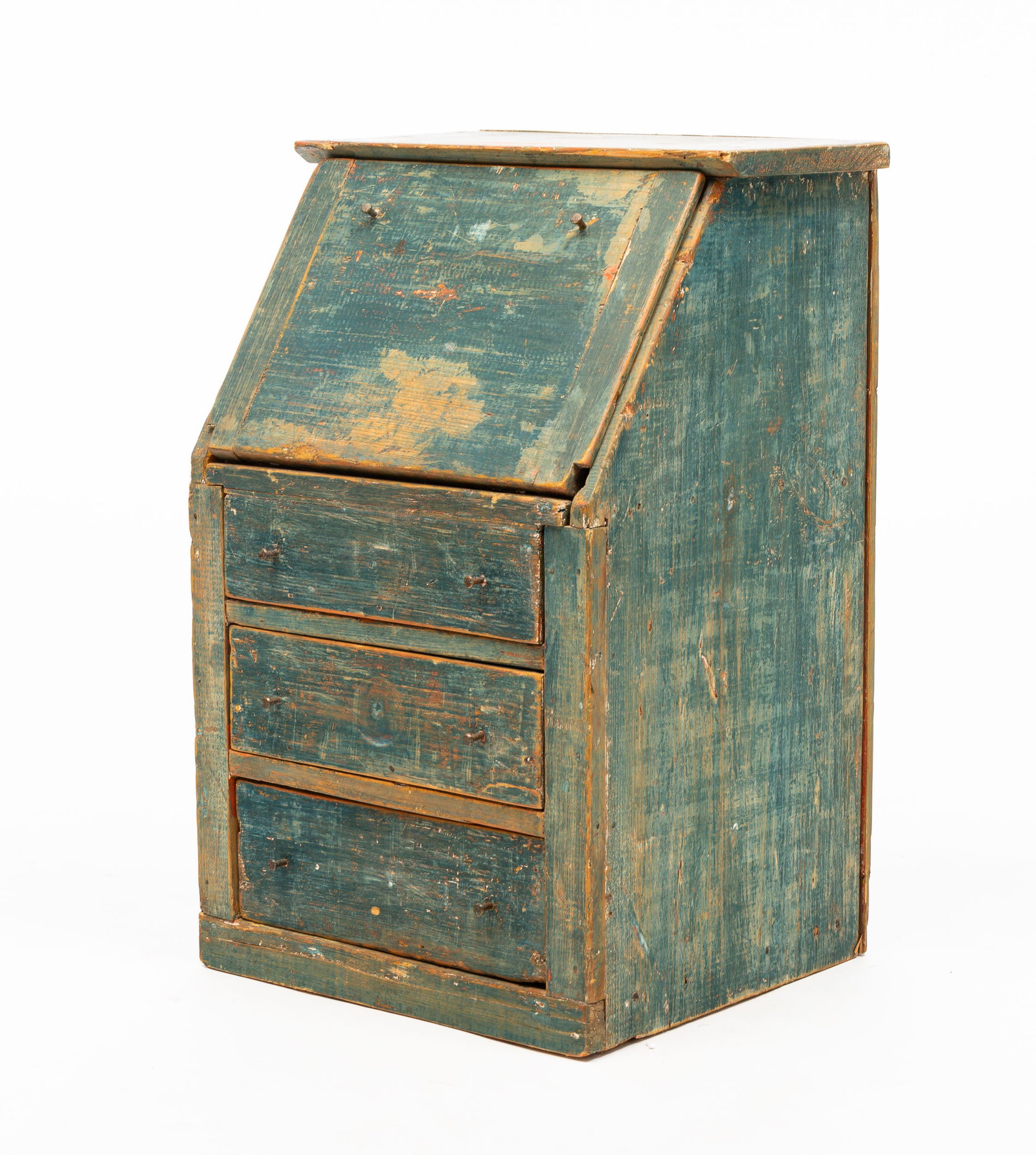 CHILD'S SLANT FRONT PAINTED PINE DESK.: American, late 19th Century. Distressed blue paint over red and yellow with tan over red interior. Overhung top board above fall-front writing surface with breadboard ends concealing fitted interior, 