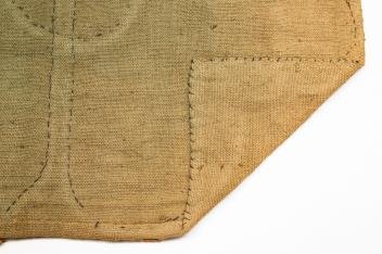 PEN WIPE FABRIC TABLE COVER.: American, 19th Century. Polychrome cotton and wool fabrics with "pennies" pieced and embroidered together in a shingled composition. Heart patterns on corners. 24" x 48". From the collection of the la