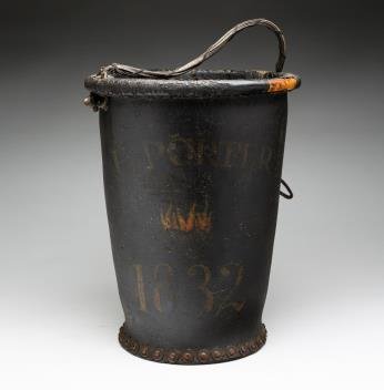BLACK PAINTED LEATHER FIRE BUCKET.: American, 19th Century. Leather, wood. Black painted fire bucket denoted "E. Porter 1832." Fire decoration in the center of the bucket. Copper rivets on the bottom of the bucket. The leather and wood 