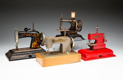 FOUR CHILD'S TOY SEWING MACHINES.