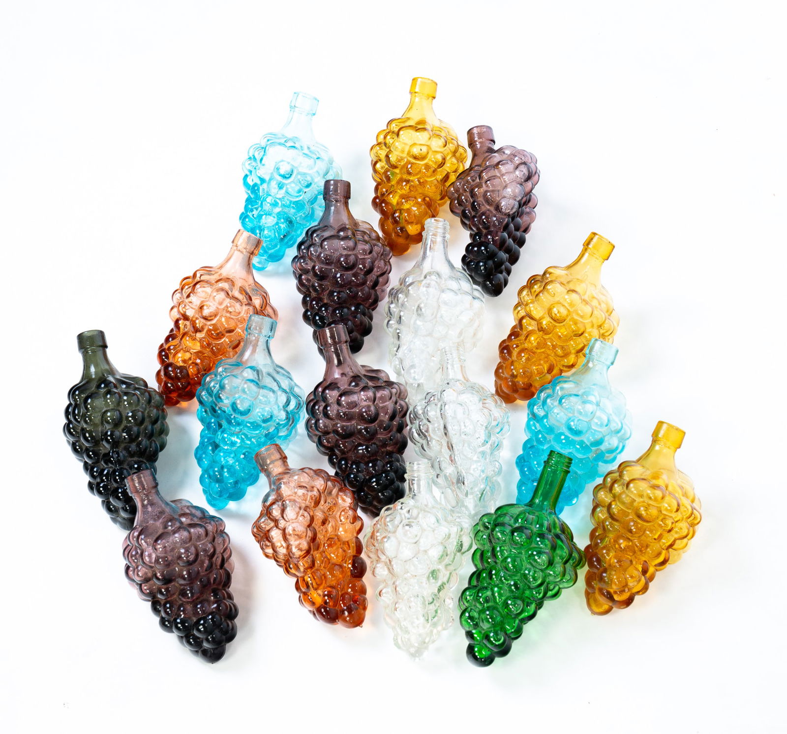 GROUP OF GLASS GRAPE FLASKS.: American, mid 20th Century. Seventeen glass grape flasks in various colors. 6.5"l.