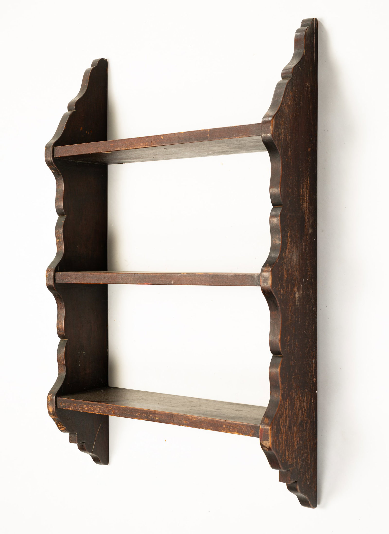 SET OF HANGING SHELVES.: American, second-half 19th Century. Poplar. Scalloped ends and three shelves with dado joints. Old dry dark finish has some wear. 34.5"h. 20.75"w. 6.5"d.
