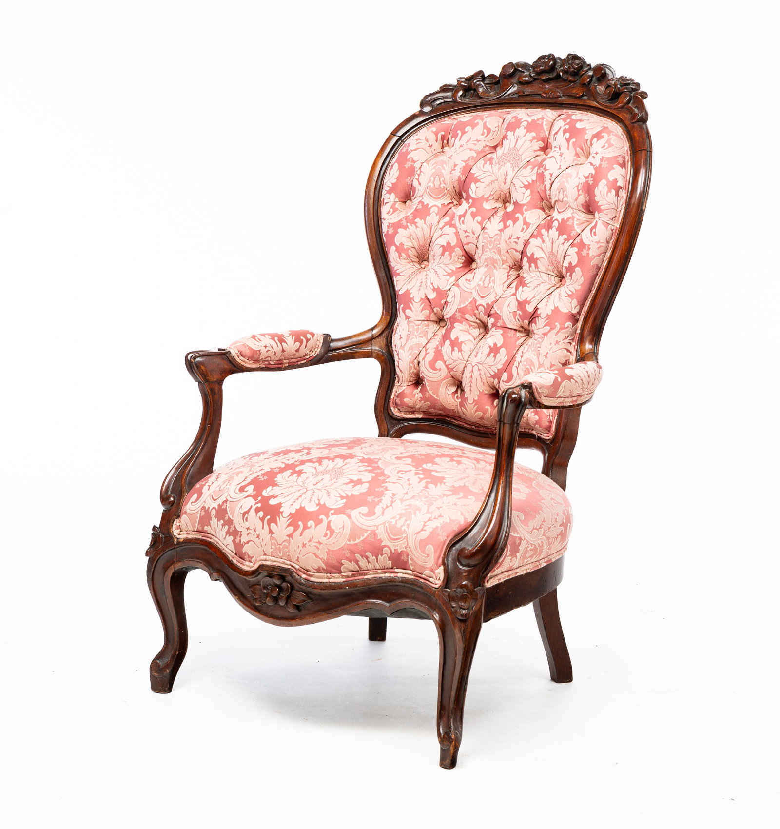 CARVED VICTORIAN GENTLEMAN'S CHAIR.: Third-quarter 19th Century. Walnut. Floral carved crest, finger carved frame and tufted floral upholstery with double corded trim. Refinished with some wear. Seat 15"h. Overall 42"h.
