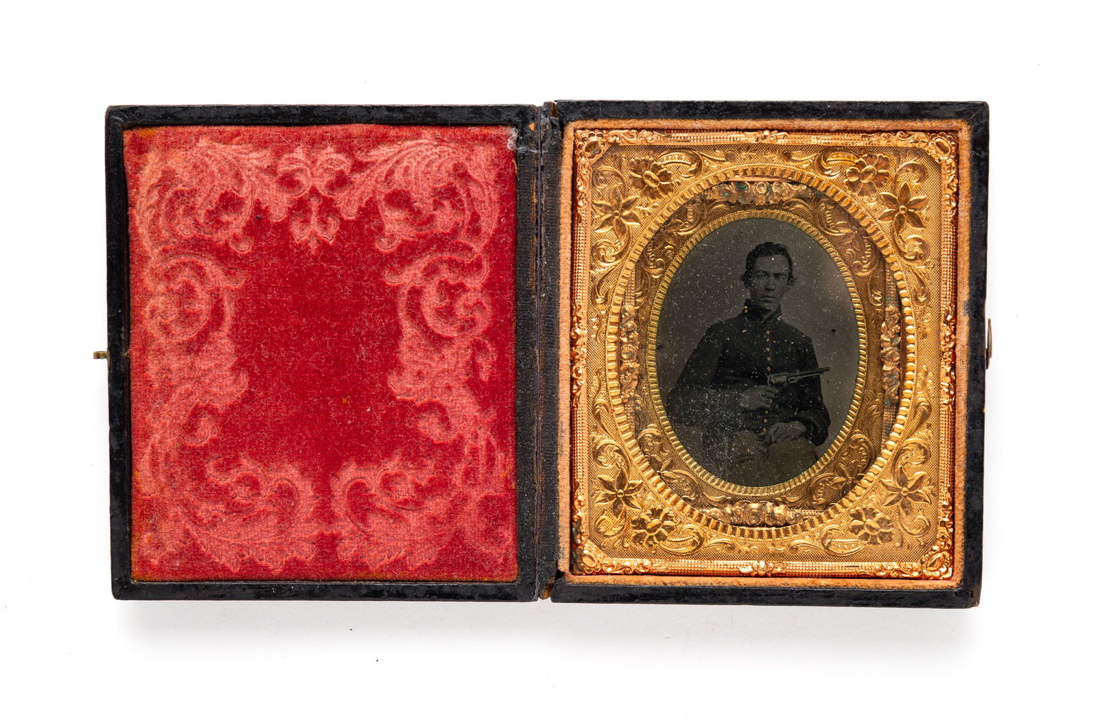 NINTH PLATE CASED CIVIL WAR IMAGE.: American, third quarter 19th Century. Tintype. Ninth plate image in a sixth plate frame. Seated uniformed soldier holding a revolver. In pressed cardboard case.