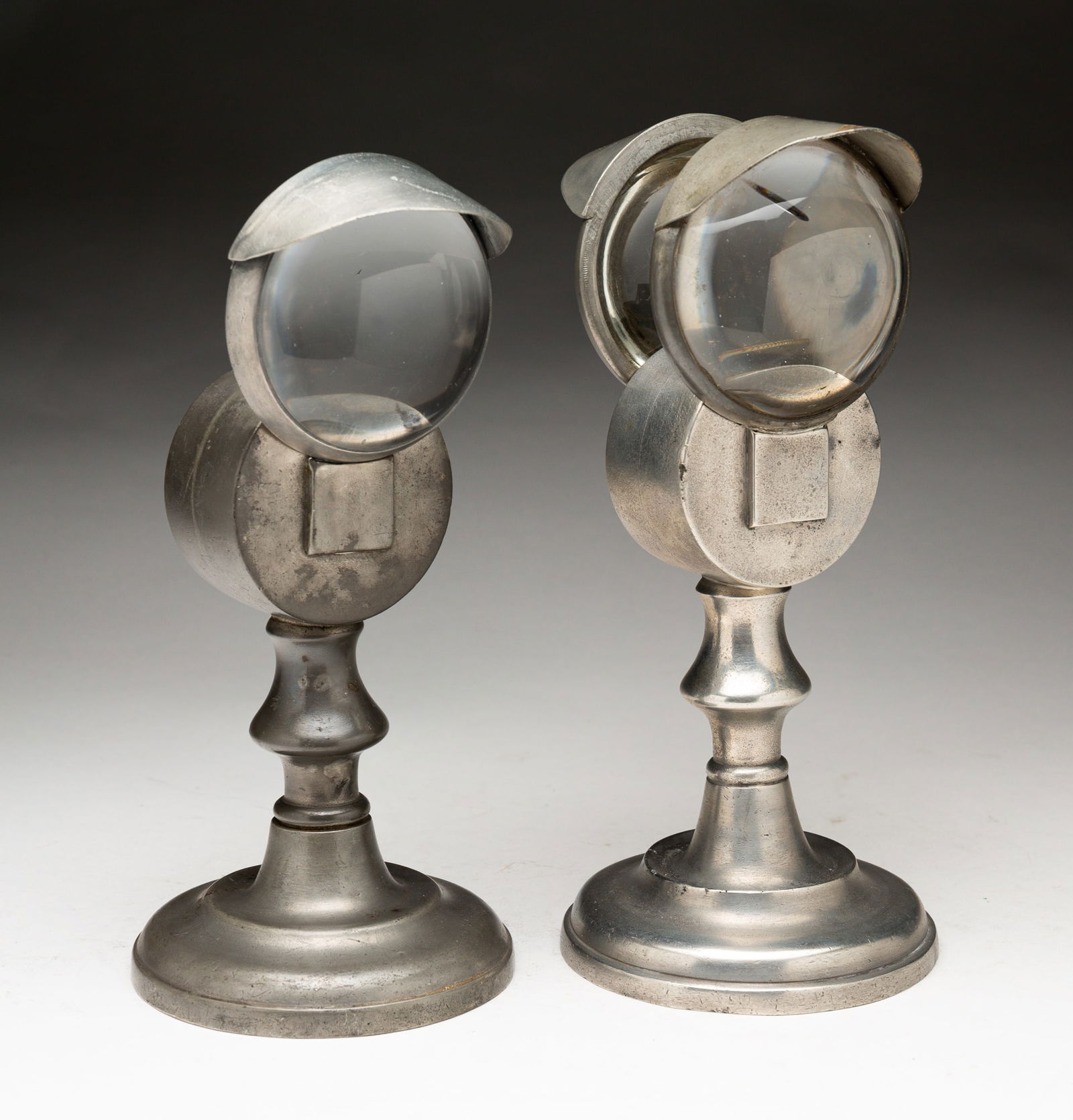 TWO BULLSEYE WHALE OIL PEWTER LAMPS.: TWO BULLSEYE WHALE OIL PEWTER LAMPS. American, mid-19th Century. A Roswell Gleason single with a baluster stem, 8.5"h. And an unmarked double bullseye with a baluster stem, 9"h. Provenance: The Collec