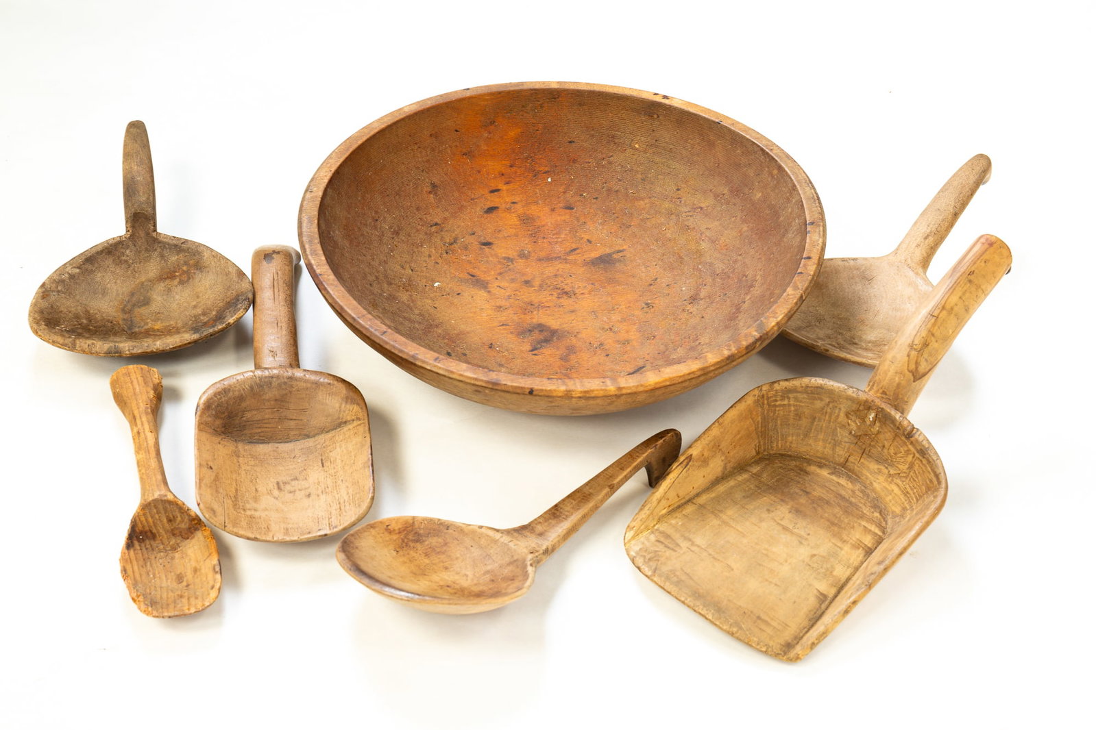 WOODEN BOWL AND UTENSILS.: WOODEN BOWL AND UTENSILS. American, second half 19th Century. Turned wood bowl with natural surface, wear and pitting. 3.25"h. 13.25" diameter. Also includes scoops, spoons and butter paddles. Varying