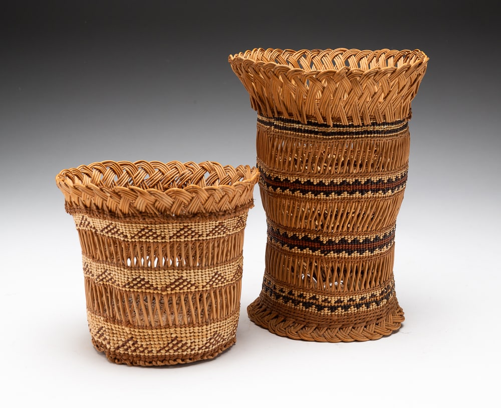 TWO NORTHWEST HUPA BASKETS.: Hupa, first half 20th Century. Two baskets crafted from beargrass and decorated throughout with classic banded designs. Excellent condition. Larger 8"h. 6"dia. Smaller 5"h. 5.5"dia.We do not guarantee