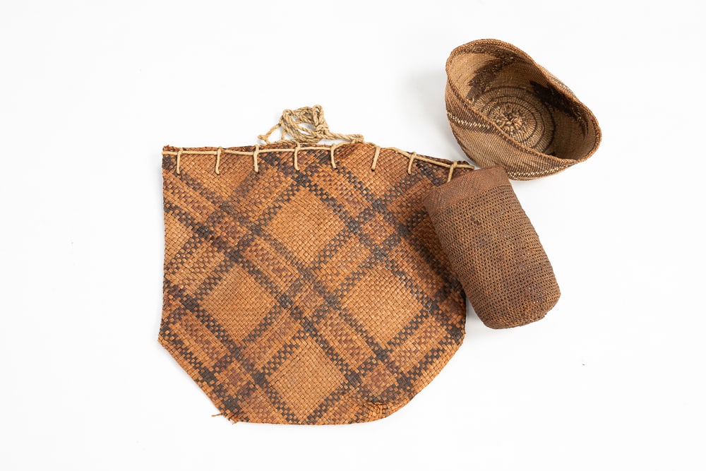 THREE NORTHWEST BASKETS, INCLUDING KLAMATH MODOC.: Early-20th Century. Southern Northwest Coast cedar bark flat bag. Overall good condition. 15"h. 15.5"w. Possible Sally bag. Break to rim, glue-repaired break in center. 8"h. 4"dia. At top. Northern Ca