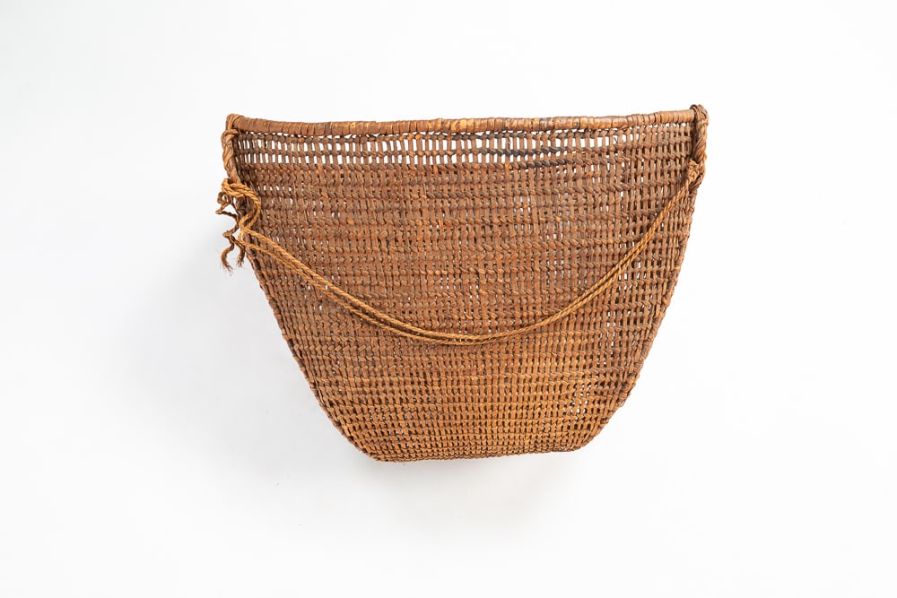 LARGE NORTHWEST COAST BURDEN BASKET.: Late-19th or early-20th Century. Large woven basket with single handle attached. Very good condition for age. 13"h. 18.5"w. 14.5"l.We do not guarantee tribal attributions for American Indian / First N