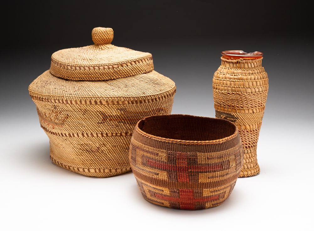 THREE NORTHWEST COAST BASKETS.: First half 20th Century. Makah or Nootka (old tag reads Neah Bay) lidded basket decorated with birds, whales, and men in canoe design. Overall good condition with even fade. 8.5"h. 9"dia. Tlingit bask
