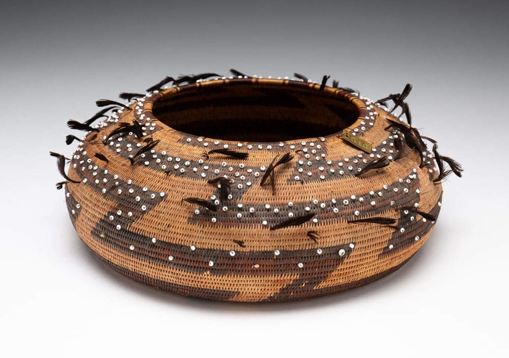 POMO FEATHERED AND BEADED BASKET.: Pomo, late-19th Century. Exceedingly fine weave. Brass insignia #516, possibly a museum tag. Excellent condition retaining most beads and feathers. 2.5"h. 8"dia.We do not guarantee tribal attributions
