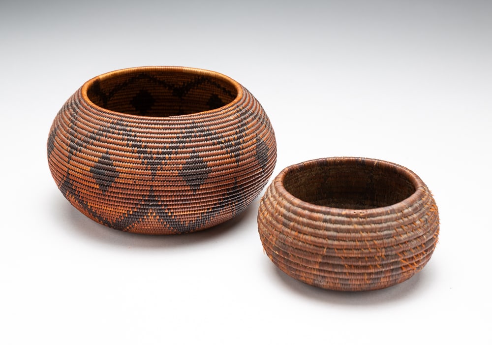 TWO POMO BASKETS.: Pomo, late-19th or early-20th Century. Dark stained with diamond decorations. Early tag notes Placer County, California. Very good condition. 2.5"h. 5"dia. Dark stain with lightning streak design with