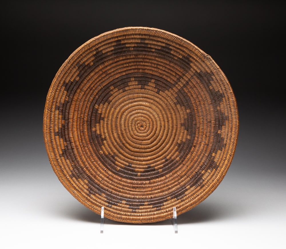 NAVAJO WEDDING BASKET.: First quarter 20th Century. Decorated throughout with an unusual "sunshine" pattern. Excellent condition. 3"h. 13"dia.We do not guarantee tribal attributions for American Indian / First Nations items.