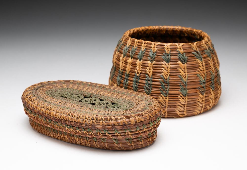 TWO COUSHATTA PINE NEEDLE BASKETS.: Coushatta, early-20th Century. Louisiana or Alabama. Bowl basket with green-dyed needle decoration. 3"h. 5" dia. Oval lidded box, very fine, intricate design on lid. Excellent condition. 1.25"h. 3.5"w