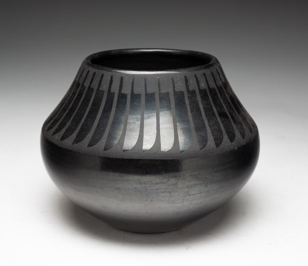 MARIA AND SANTANA SAN ILDEFONSO POT.: San Ildefonso, mid-20th Century. Blackware pottery jar with high polish and repeating feathers. Very good condition. Signed "Maria & Santana" on underside. 4"h. 5.5"dia.We do not guarantee tribal attr
