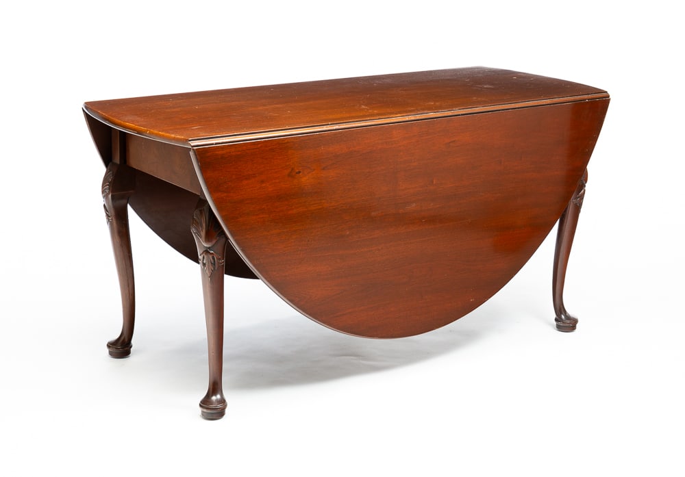 QUEEN ANNE STYLE DINING TABLE.: American, second half 20th Century. Mahogany. Oval top and cabriole legs with carved knees and pad feet. Two legs swing to support leaves. 29"h. 58"w. 69.5" open with 24" leaves.