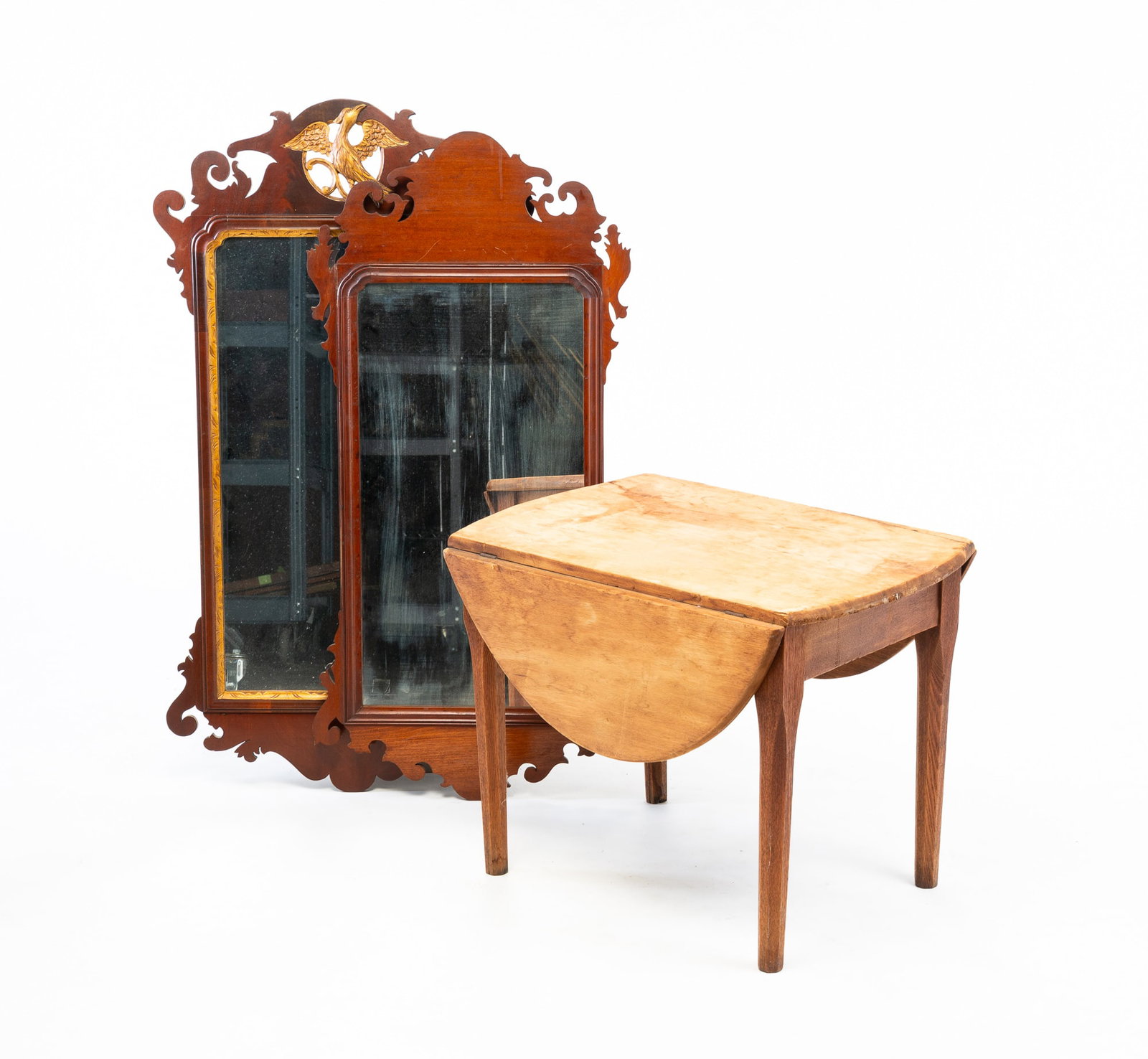 TWO CHIPPENDALE SCROLL MIRRORS AND A TABLE.: American, 19th Century. The first with beveled gilt border and scrolled frame, the pierced crest adorned with a gilt phoenix. Replaced mirror with original back. 42"h. 22.75"w. The second with beveled