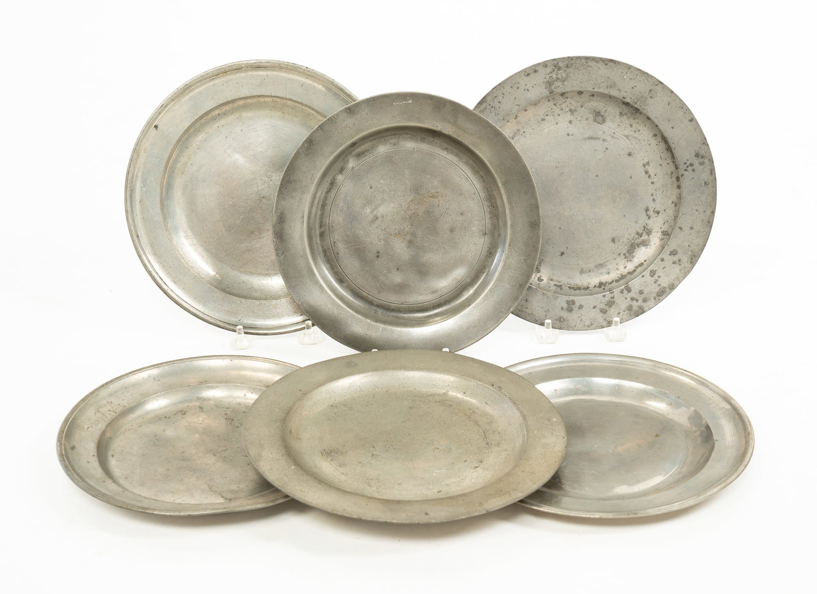 SIX PEWTER PLATES.: Varying origins, first half 19th Century. Two unmarked, one marked C. Gundermann, three marked London and with touchmarks. All with wear, one with corrosion, two with dented centers. 8.5"dia. to 9.25"