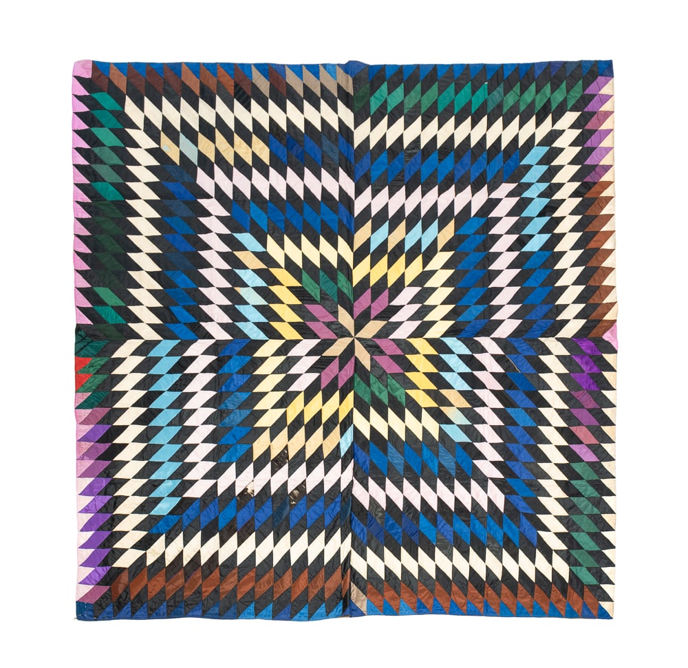 PIECED "STARBURST" QUILT.: American, second half 19th Century. Polished cotton. Colorful pieced Starburst variant with solid beige back. Handwritten note sewn to back reads "This quilt belongs to T.H. Benedict. Made by his gran