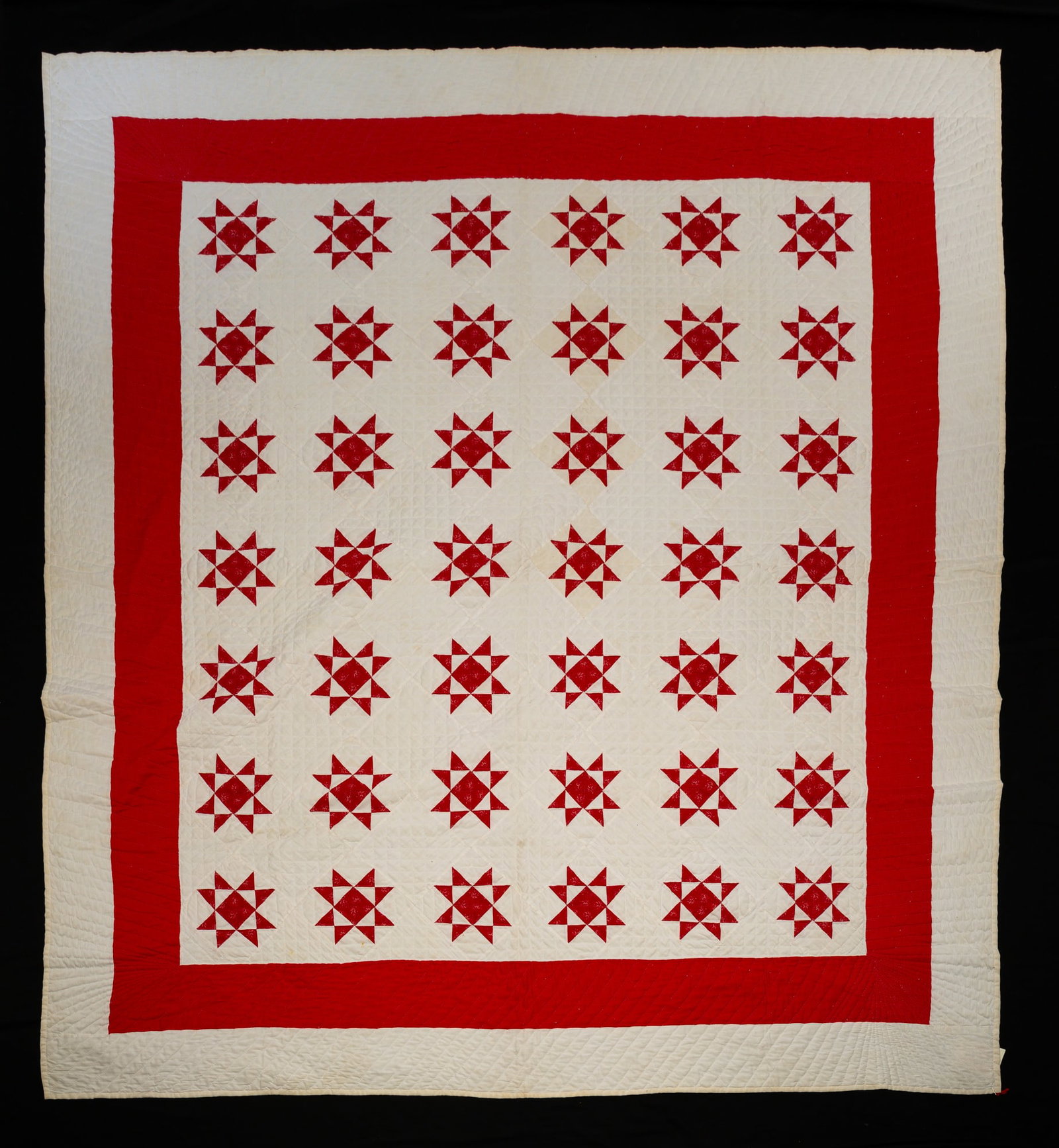PIECED "DUCKS ON A POND" QUILT.: American, first quarter 20th Century. Hand-stitched in red-patterned fabric on white field. The border in solid red and white. Three very small stains near one edge of field, one small stain on back. 