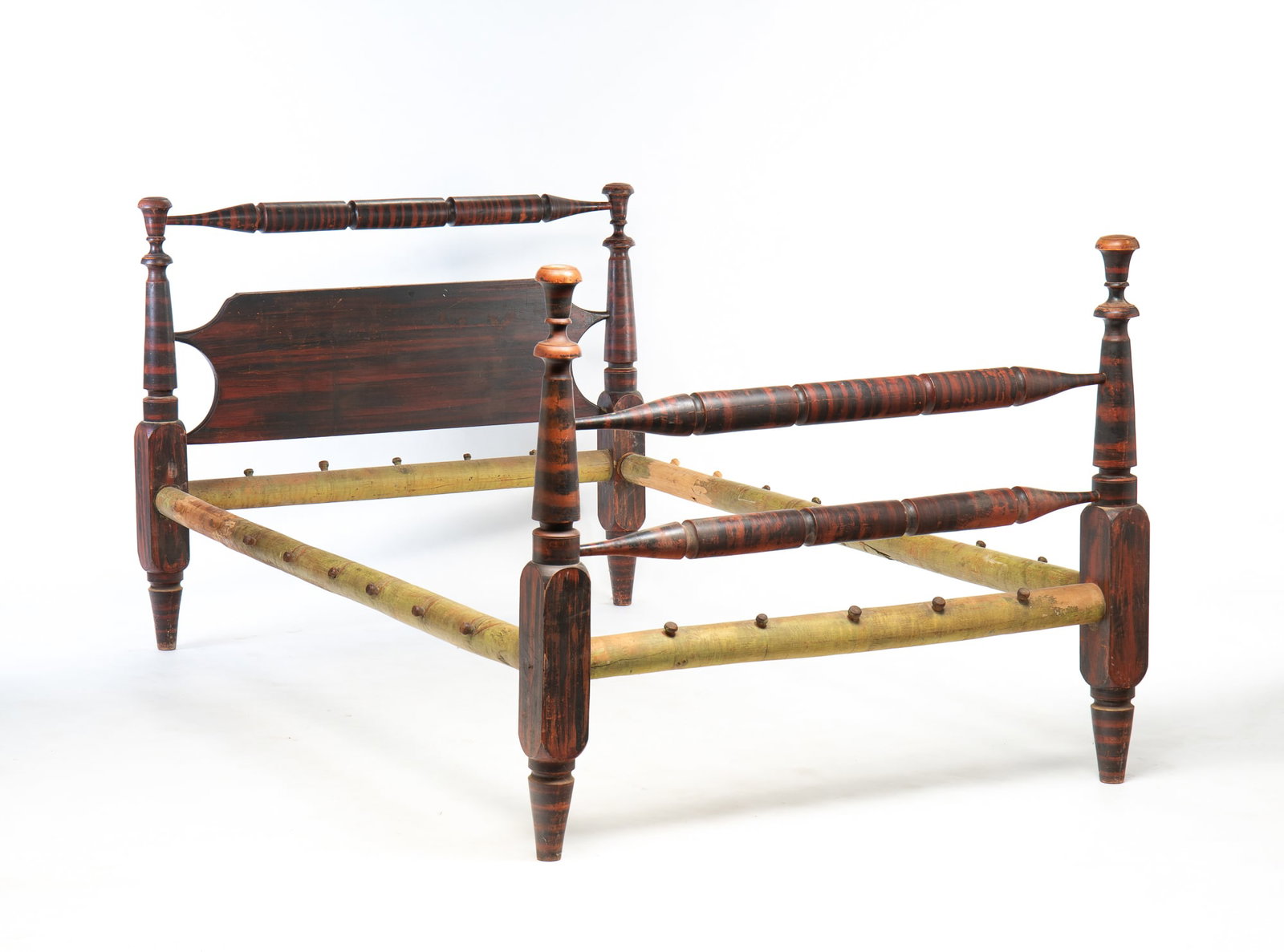 GRAIN PAINTED ROPE BED.: American, second quarter 19th Century. Turned posts with torch finials and threaded side rails. Original black and red graining. Wear and loss. 42"h. 52.5"w. 84"l.