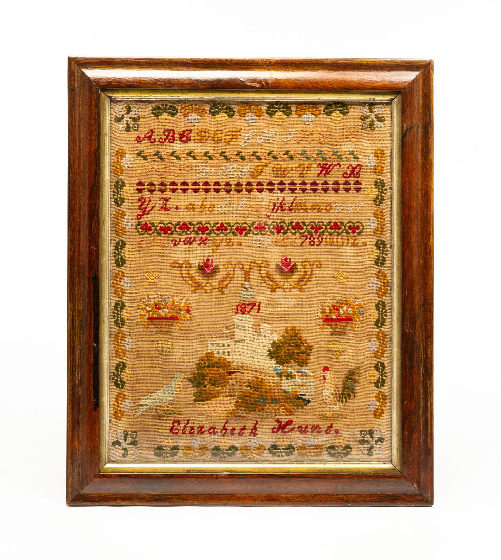 NEEDLEWORK SAMPLER.: English, dated 1851. Wrought by “Elizabeth Hunt". Alphabet and numerals, roses, floral urns, castle, dove, and rooster and floral border. Tacks visible at edge of the linen. Framed 26”h. 2