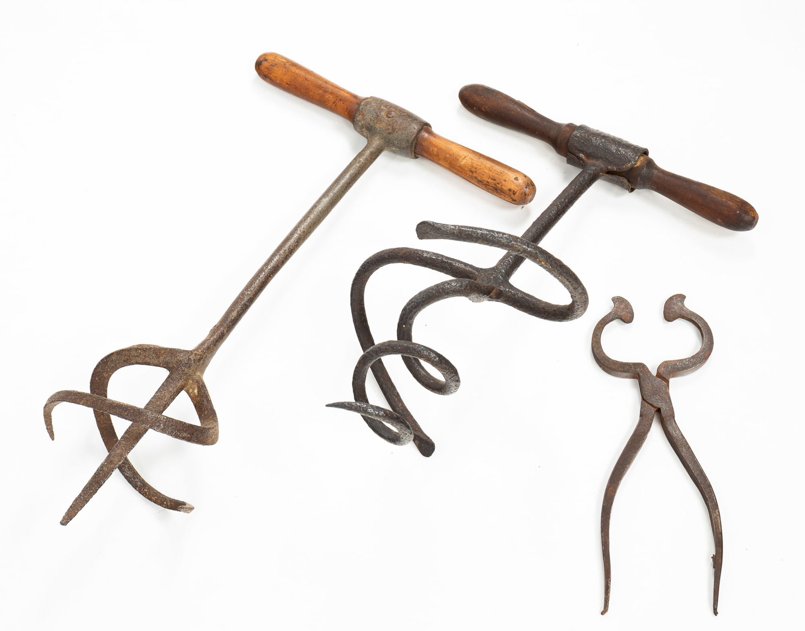THREE SUGAR TOOLS.: American, 19th Century. Sugar devil, iron with turned-wood handle. 14”h. Handle 9.5”w. Auger 7.25”w. And a sugar devil, iron with illegible embossing, turned-wood handle. 15.75”