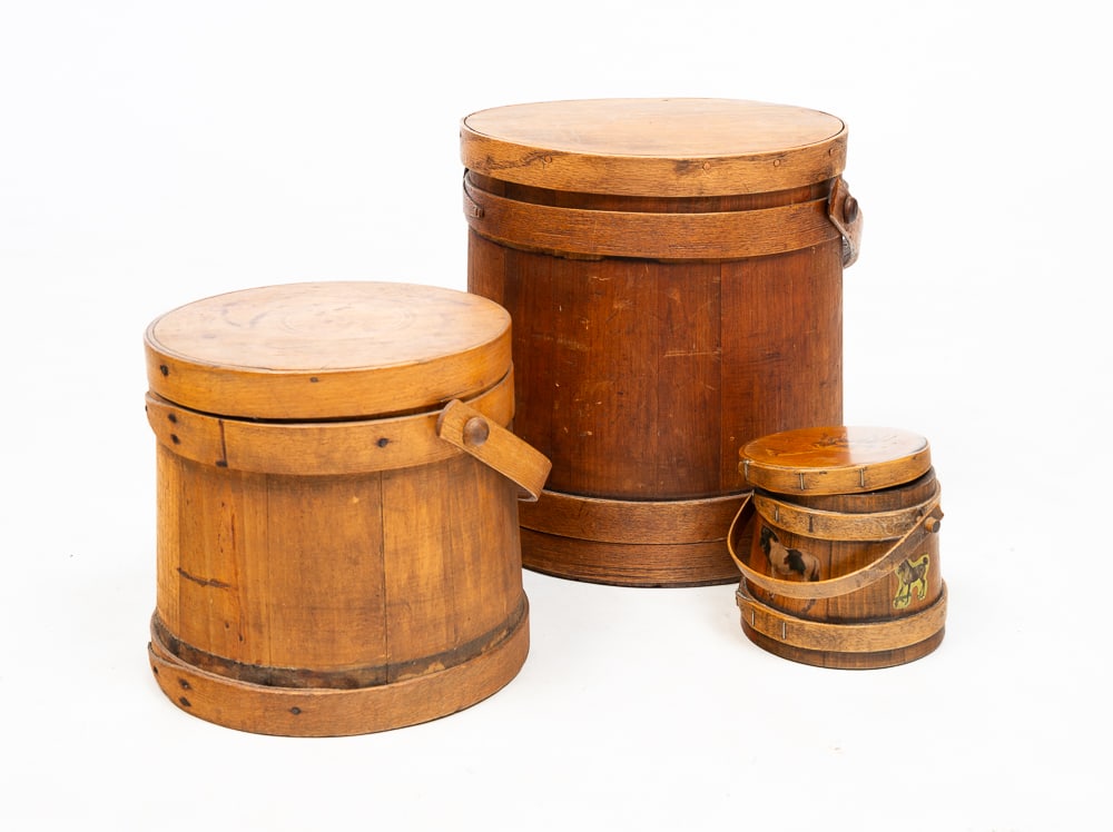 THREE LIDDED FIRKINS.: American, mid-19th Century. Stave constructed firkin with bentwood bail handle and finger joints. Mismatched lid, wear, and losses. 12.5"h. Stave constructed firkin with bentwood bail handle and finge