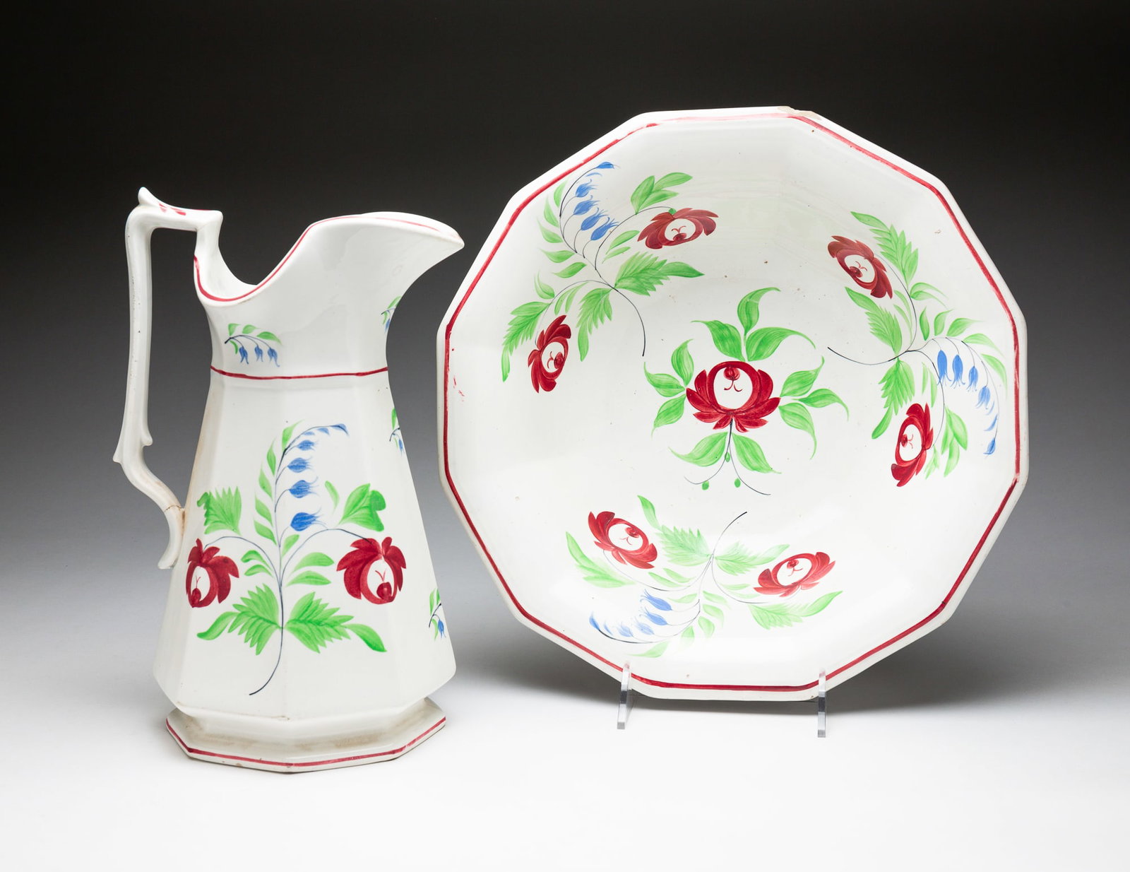 STICK SPATTER PITCHER AND BOWL.: English, third quarter 19th Century. Ironstone China. Paneled form with floral decoration and red stripe borders. Pitcher has hairlines, bowl has rim chip and both have wear. Pitcher 18.75"h. Bowl 4.7