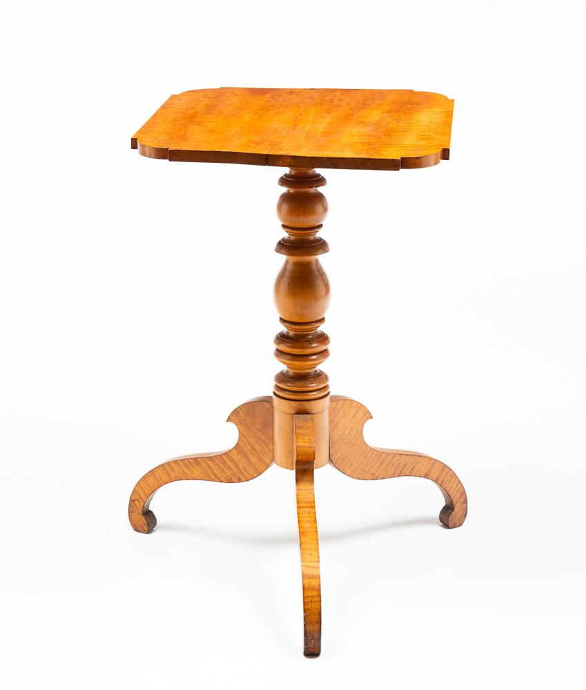 EMPIRE CANDLE STAND.: American, second quarter 19th Century. Tiger maple. Rectangular top with ovolo corners, turned column and scrolled legs. Refinished with repairs to column base. 28"h. 18.5"w. 17"d.