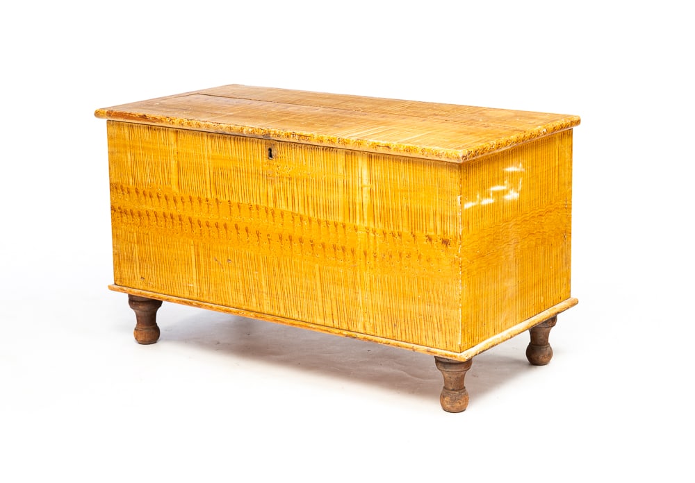 GRAIN PAINTED COUNTRY EMPIRE BLANKET CHEST.: American, second quarter 19th Century. Pine. Lid with breadboard ends, dovetailed case, short turned legs, interior lidded till and warm pine colored graining. Age split on lid and some paint wear. 21