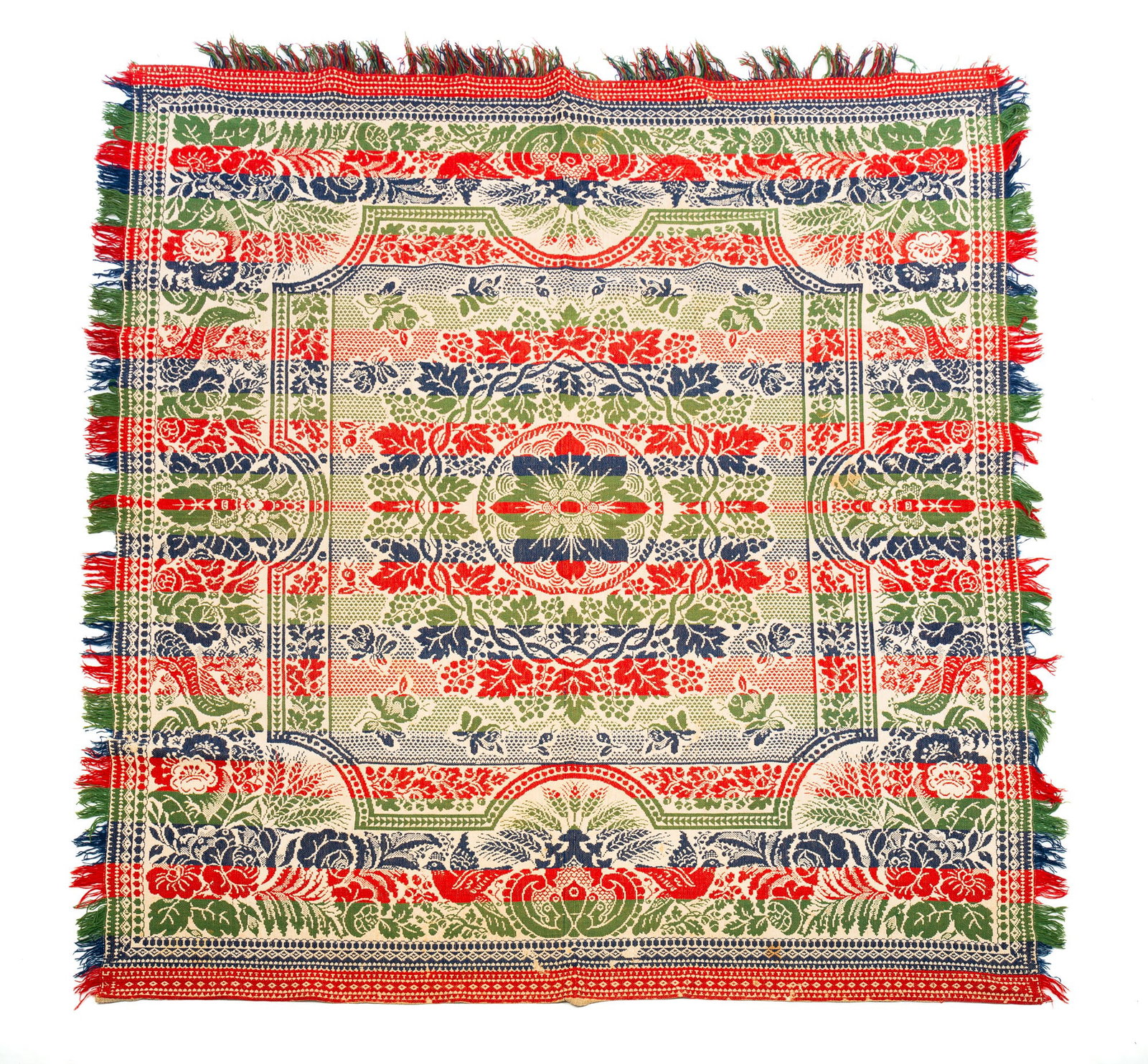 FOUR-COLOR COVERLET.: American, mid-19th Century. Blue, red, green, and natural. Central floral medallion with grape vine surround; border with birds, peacocks, flowers, and wheat. A few areas of wear and a few scattered s