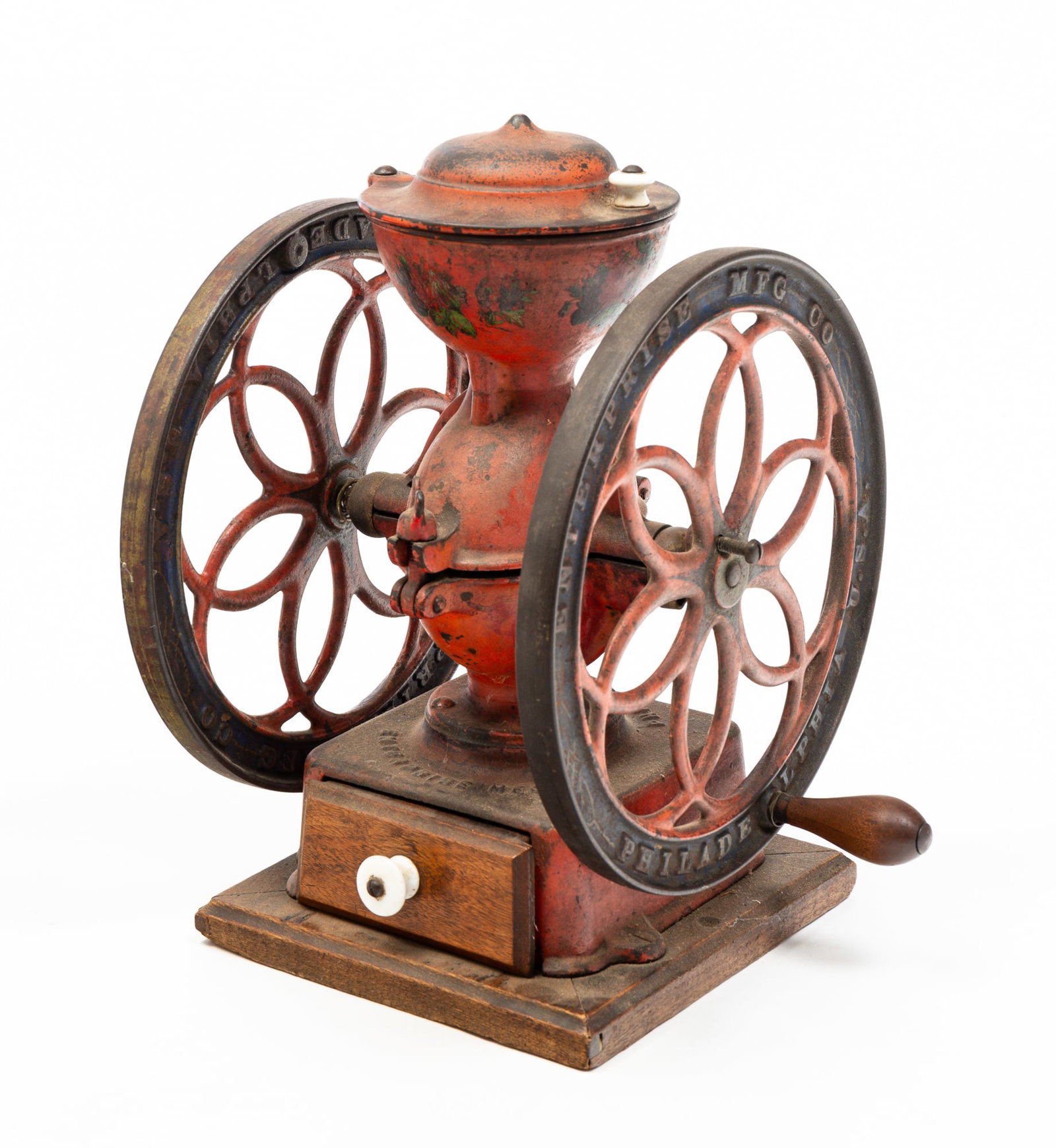 ENTERPRISE COUNTER TOP COFFEE MILL.: American (Philadelphia, Pennsylvania), late-19th Century. Cast Iron. Original worn red, blue and gold paint, floral decals, walnut and poplar drawer and walnut base. Some wear and edge loss. 15"h.