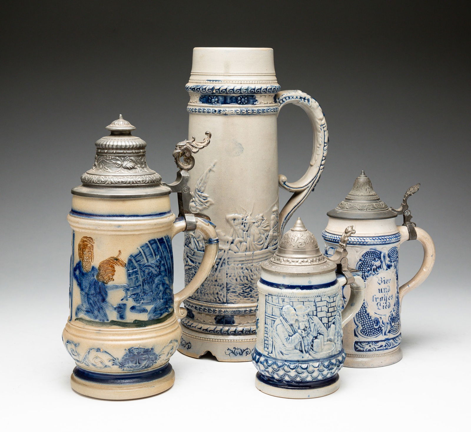 FOUR BLUE AND GRAY SALT-GLAZED STONEWARE STEINS.: American, late-19th Century. Attributed to Whites Pottery, Utica, NY. The first molded with scene of Washington crossing the Delaware. Impressed "8" on underside. Hairline crack to interior top rim. 1