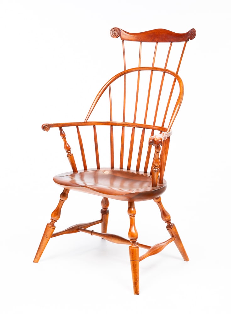 RICHARD GRELL COMB-BACK WINDSOR ARMCHAIR.: American, dated 1992. Maple and oak. Crest with scrolled lobes, spindle back, knuckle arms, turned stiles, legs and stretchers with saddle seat. Seat 16.75"h. Overall 44"h.