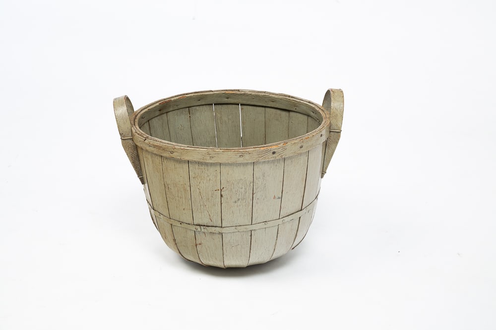 A PAINTED DOUBLE-HANDLED BASKET.: American, 19th Century. Oak bushel basket with two bentwood handles, with an allover greenish-gray paint wash.dimensions are 15"W 12"H