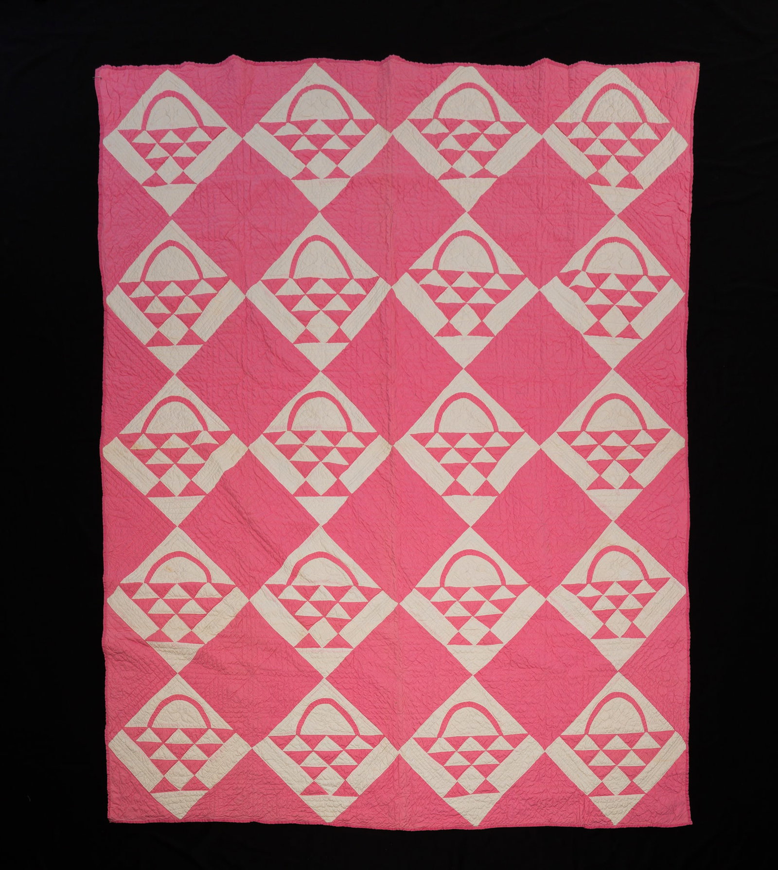 PIECEWORK QUILT IN FLOWER BASKET PATTERN.: American, 20th Century. Pink and White blocks. Staining and some discoloration. 67"w. 170"l.