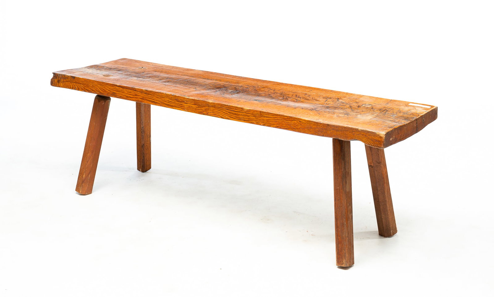 PRIMITIVE BENCH.: American, circa 1900. Oak and pine. One board seat and splayed octagonal legs. Refinished, age splits and the two pine legs may be replacements. 17.5"h. 53"w.