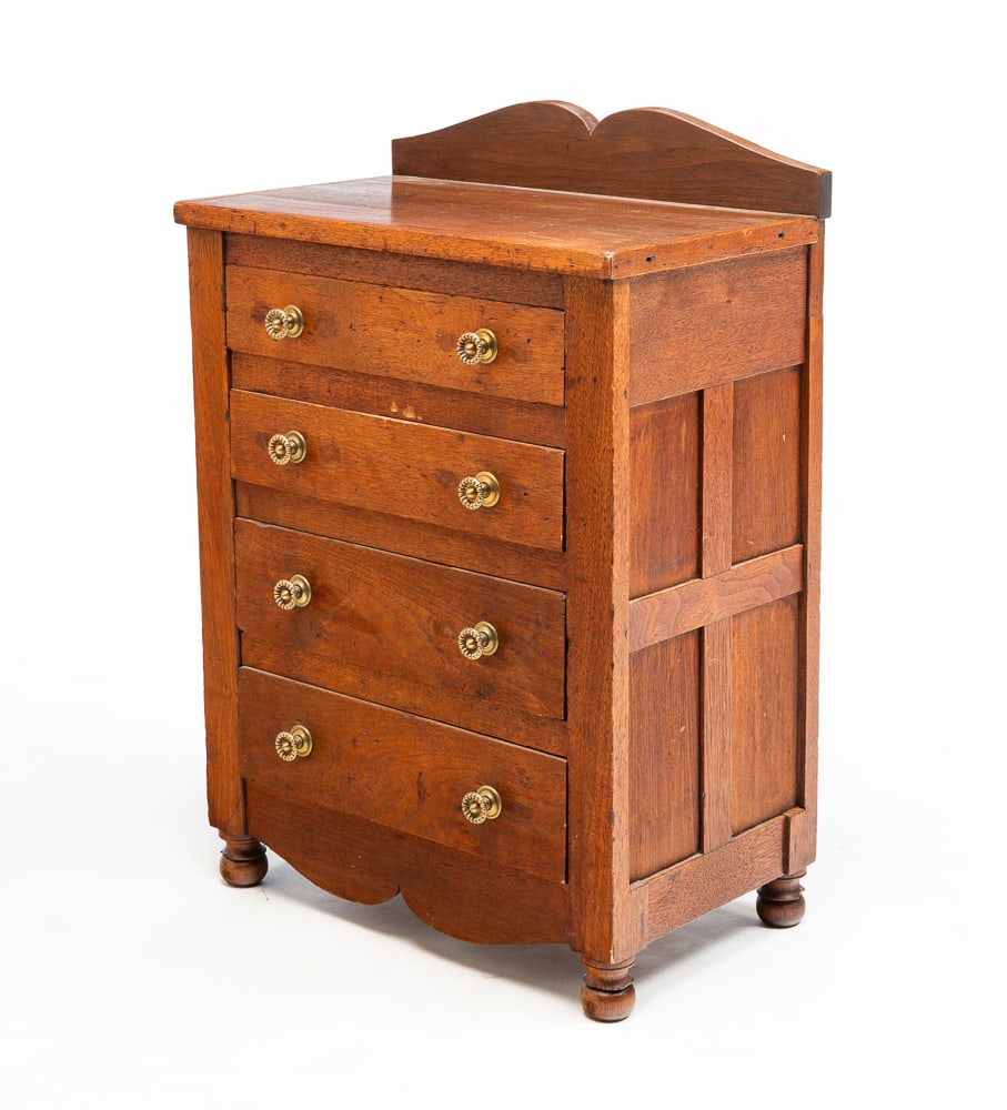 YOUTH SIZE CHEST.: American (Pennsylvania), third quarter 19th Century. Walnut with poplar secondary. Shaped backsplash with four panels four drawers, shaped apron and ball feet. On the bottom of top drawer "Miss Maud M