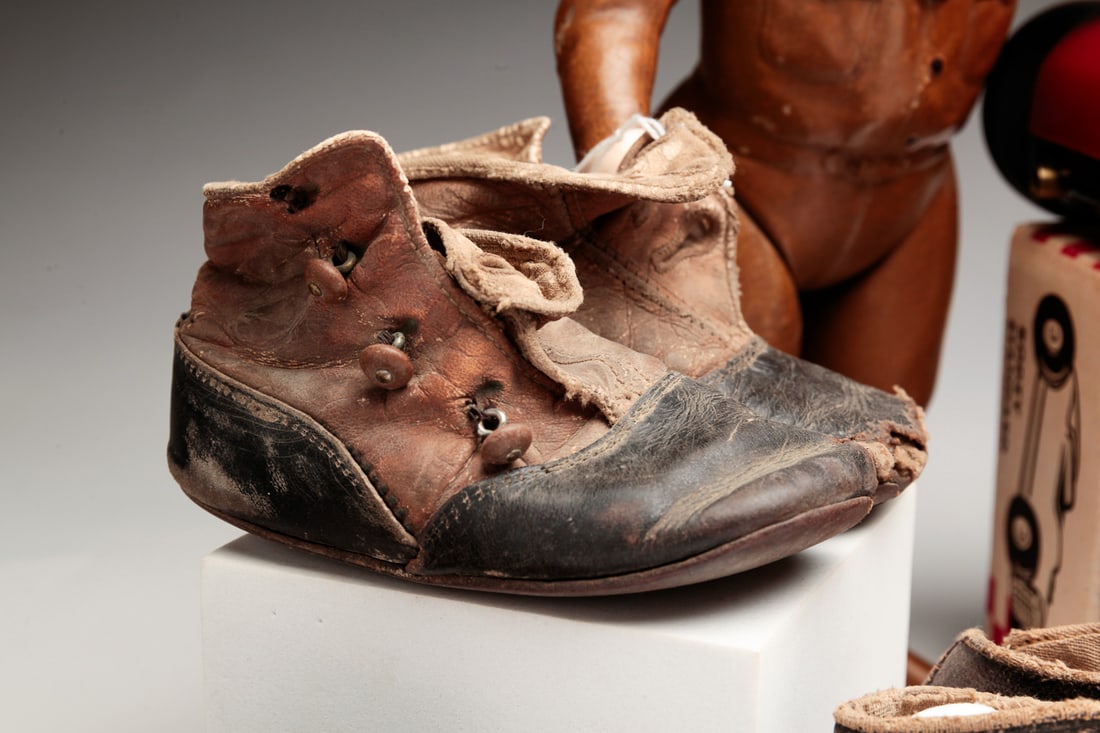 GROUP OF CHILDREN'S ITEMS.: American, 20th Century. Four pairs of shoes, wear, and "Ideal" World War I doughboy jointed doll, composition with some wear. 12.25"h. A "Tonka" Twinkle Toes Volkswagon beetle toy, wear, "All American