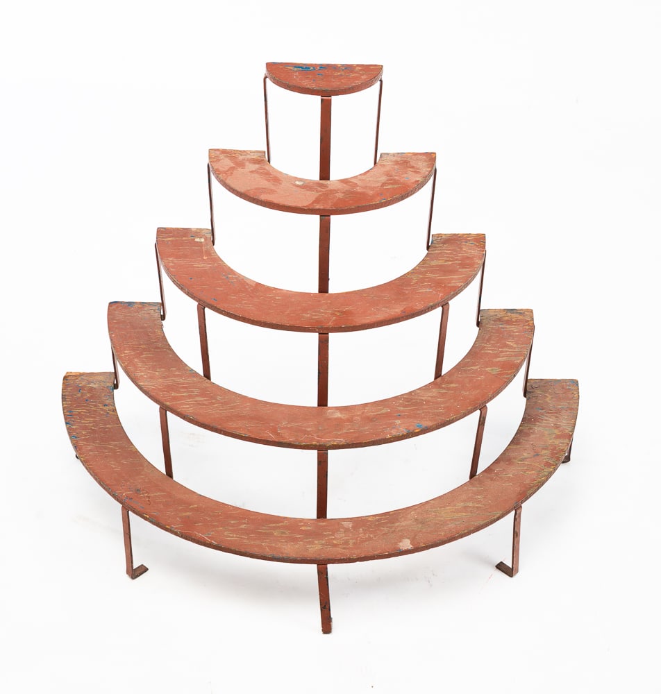 HALF ROUND SMALL PLANT STAND.: American, first half 20th Century. Flat metal frame with plywood shelves, five stepped shelves with rust red paint over blue. Some wear and paint loss. 25.5"h. 29.25"w. 14.75"d.
