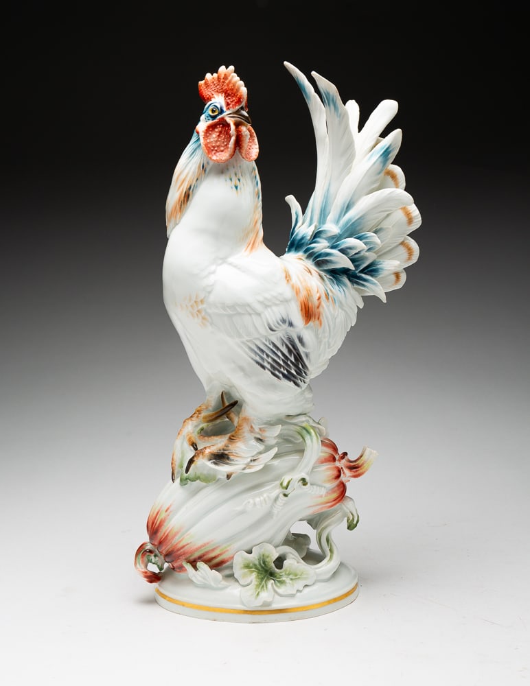 LARGE MEISSEN PORCELAIN ROOSTER FIGURINE.: German, 20th Century. Well detailed bird perched on a gourd. Oval base, colorful decoration. Crossed sword mark under an impressed P.W. on underside impressed 76 and incised KL 37. Small chip on table