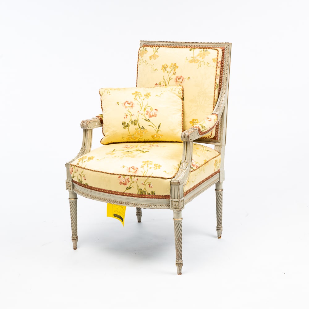 LOUIS XVI STYLE OPEN ARMCHAIR.: European, 20th Century. Mixed woods. Square back, curved front, foliate carving, rope turned front legs, worn gray paint and gilded highlights. Scalamandre upholstery in pale yellow with floral patter