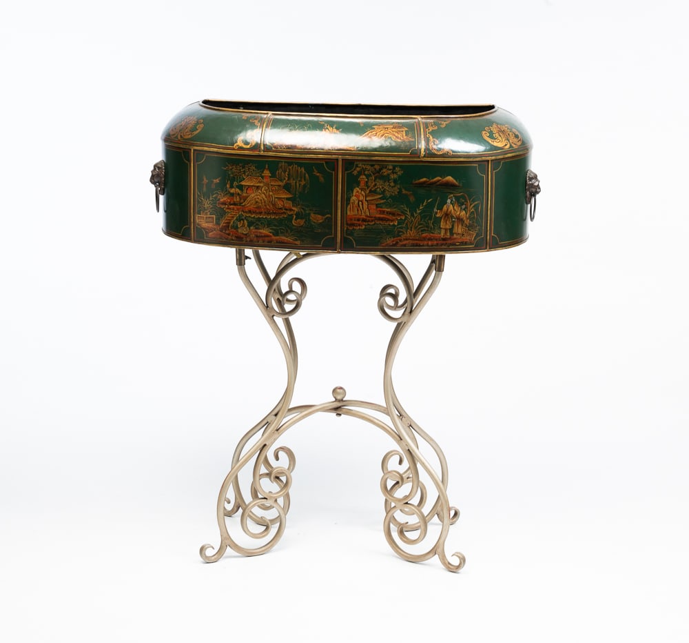 THEODORE ALEXANDER TOLE PLANTER.: Asian, Contempory. "D" front with rounded cowling, gold Chinoiserie decoration on a dark green background. Lion's head ring handles and scrolled iron base with silver base. 34.5"h. 31"w. 12.25"d.