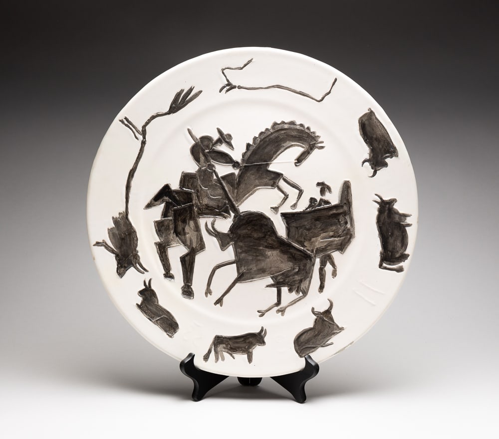 CORRIDA CERAMIC CHARGER BY PABLO PICASSO (1881-1973).: Madoura Studios (Vallauris, France), 1953. White earthenware ceramic plate with oxidized paraffin decoration and white enamel bath depicting a picador, matador and bull to center with seven bulls to r