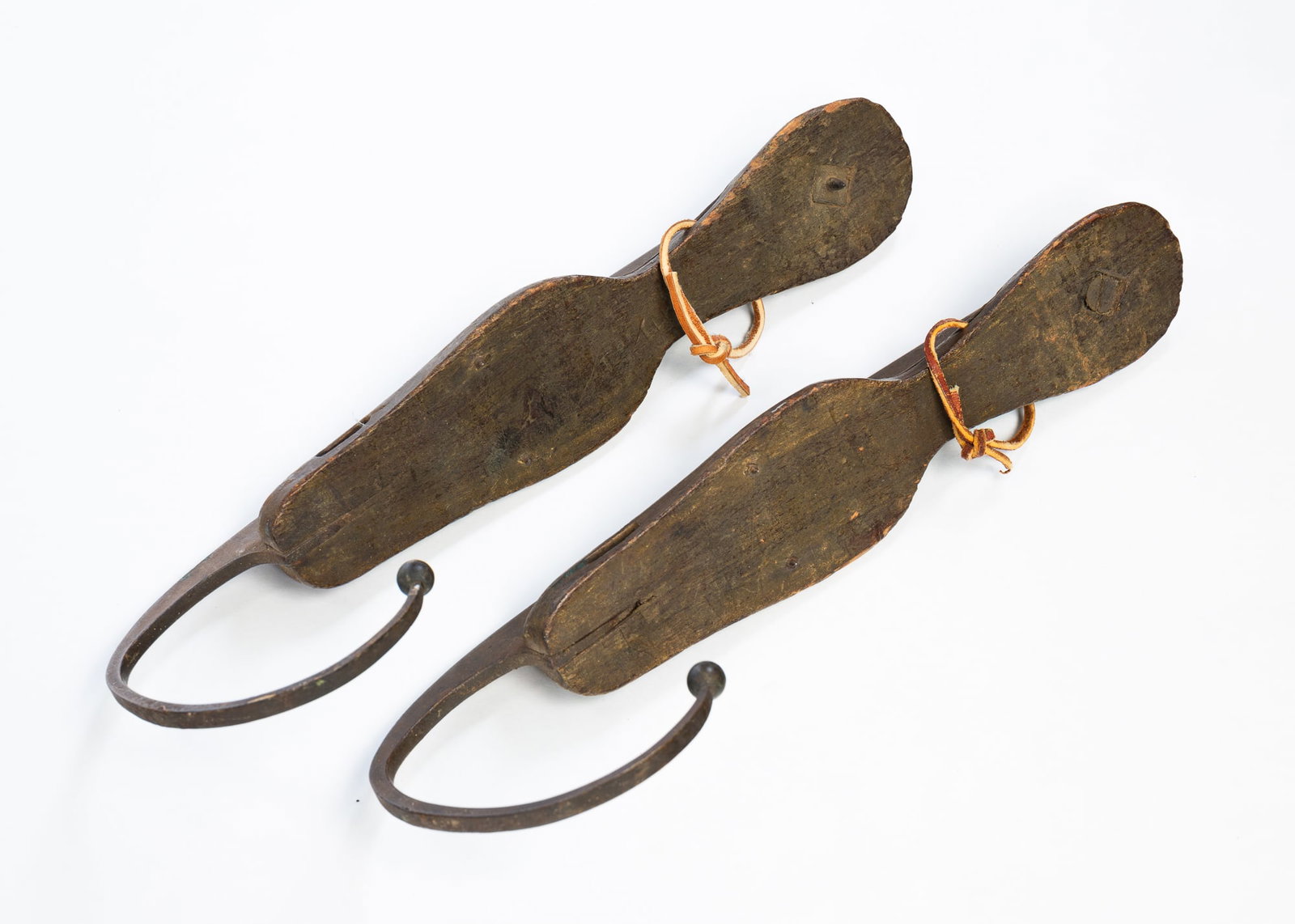 PAIR OF WIRTH'S ICE SKATES.: American, 19th Century. Forged iron blades with a "C" curved toe terminating in a ball. Wooden shoe plates. "Wirths" Impressed mark to blades. 13.5"l.